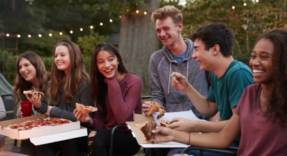 Ungdommer som spiser pizza sammen