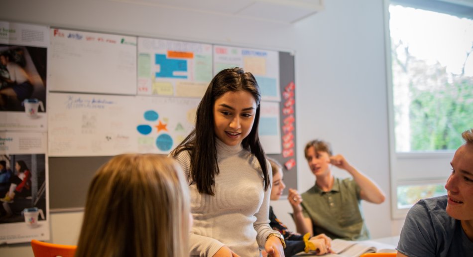 Lærerstudent i samtale med elever i klasserommet